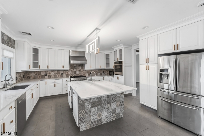 99 Ogle Road Old Tappan, NJ 07675 - Photo 7 of 35 a kitchen with stainless steel appliances granite countertop a refrigerator a sink dishwasher a stove with white cabinets and wooden floor