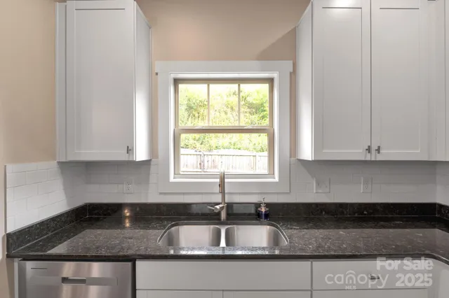 a kitchen with granite countertop a sink and a window