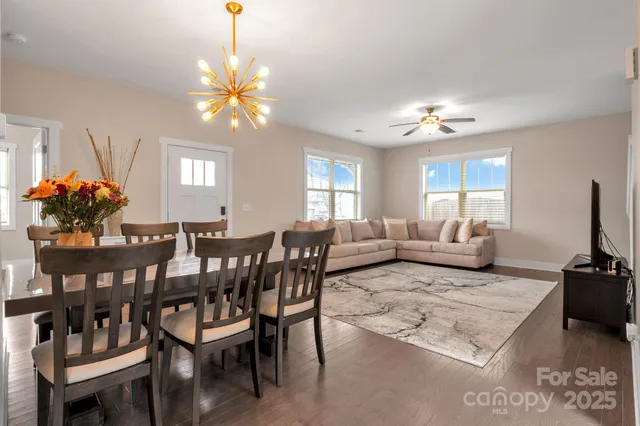 a living room with furniture a chandelier a rug and a window