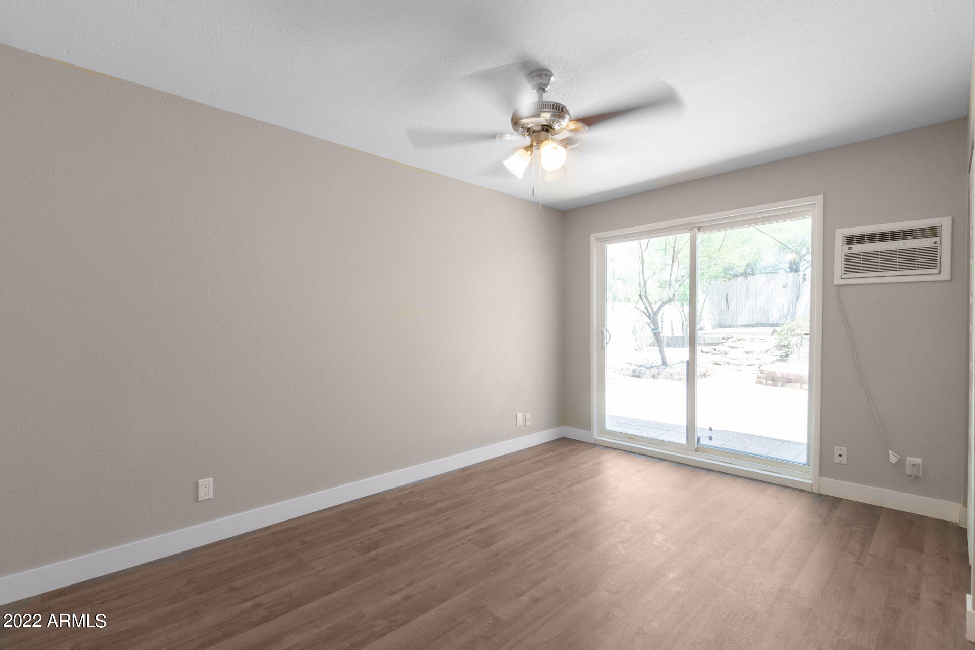 1036 East Butler Drive Phoenix, AZ 85020 - Photo 14 of 25 a view of an empty room with wooden floor and a window