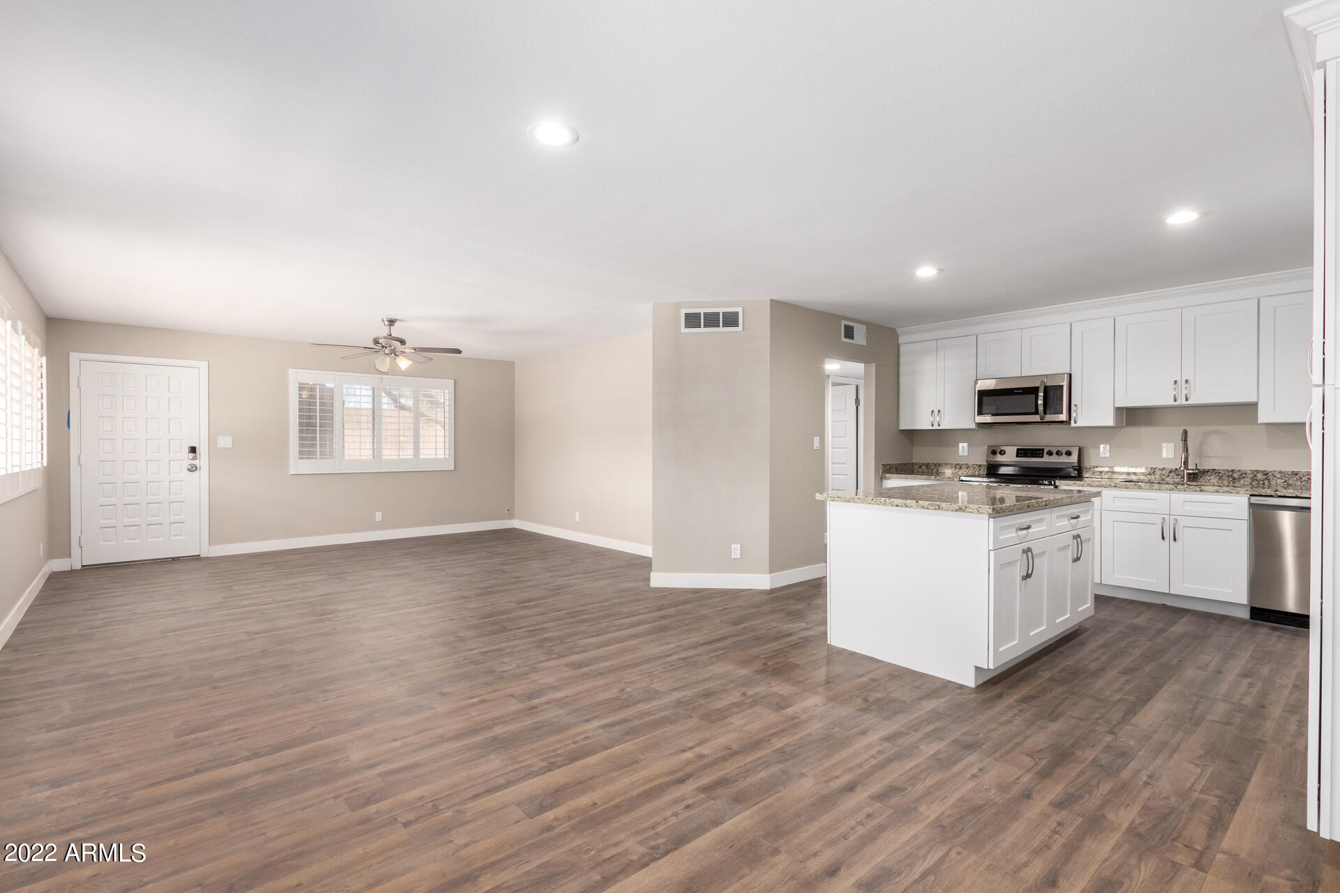 1036 East Butler Drive Phoenix, AZ 85020 - Photo 2 of 25 a kitchen with granite countertop a white stove top oven cabinets and a wooden floor