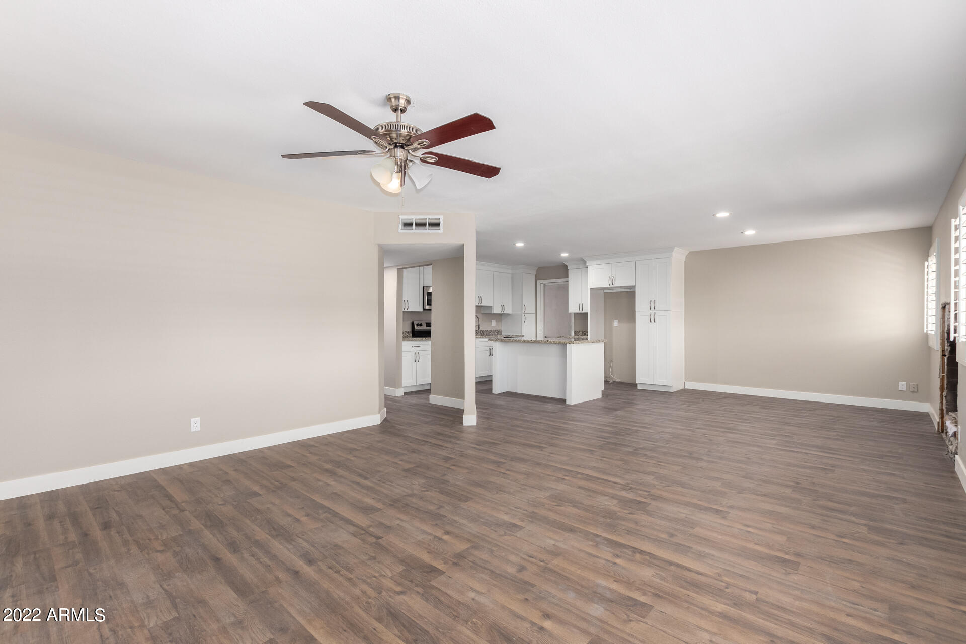 1036 East Butler Drive Phoenix, AZ 85020 - Photo 3 of 25 a view of an empty room with wooden floor and a ceiling fan