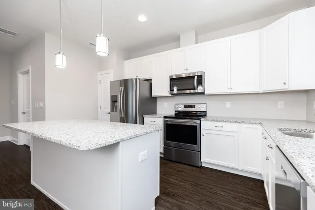 a kitchen with stainless steel appliances granite countertop a refrigerator and a sink