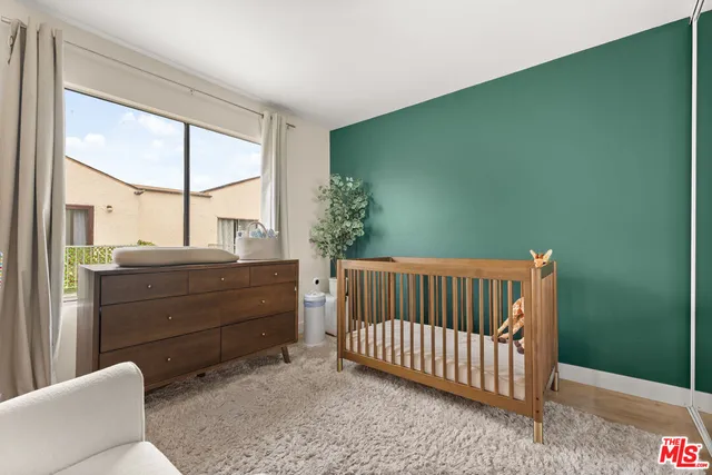 a room with a baby crib and a window