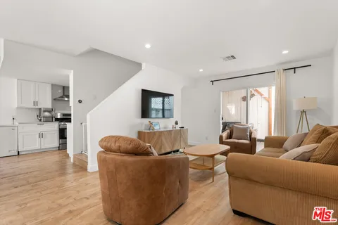 a living room with furniture and view of kitchen