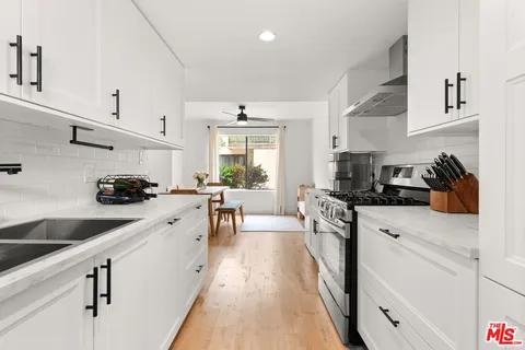 a kitchen with white cabinets sink and white appliances