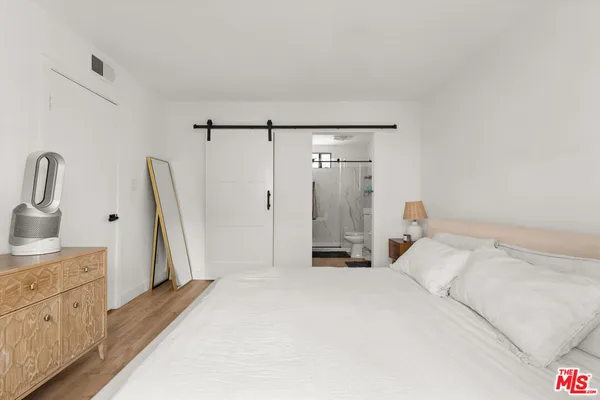 a spacious bedroom with a bed and a dresser