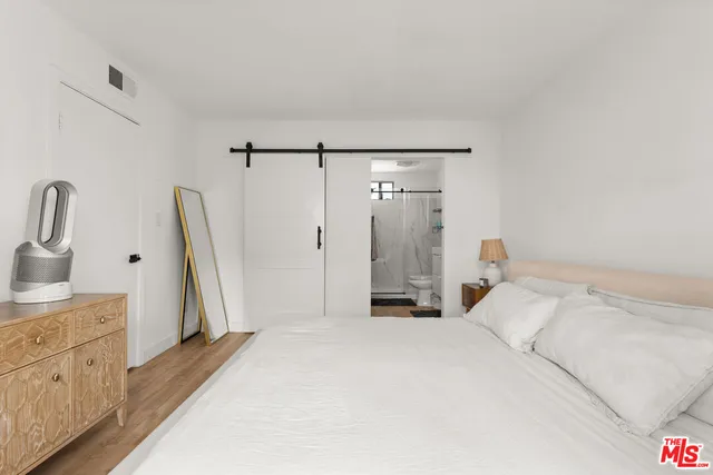 a spacious bedroom with a bed and a dresser