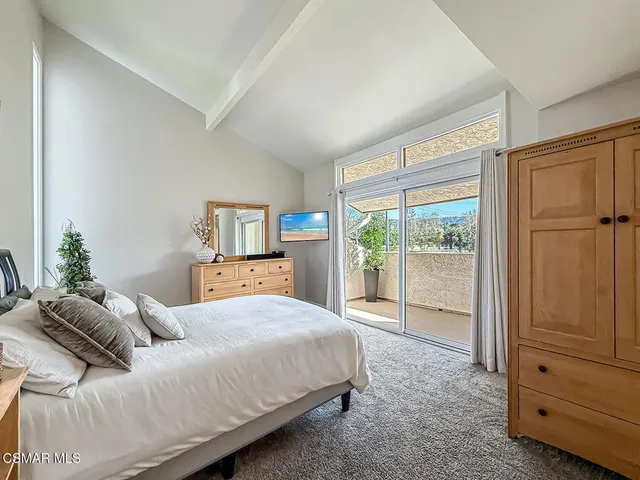 a spacious bedroom with a bed and a large window