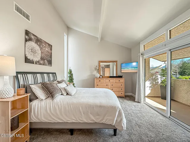 a bedroom with a bed and glass door