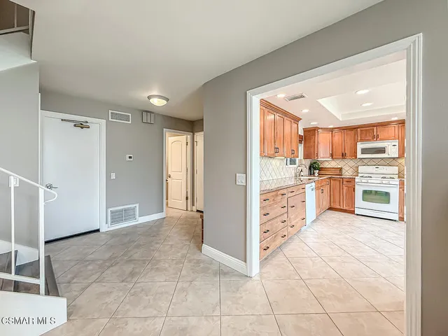 a view of a kitchen with wooden floor and electronic appliances