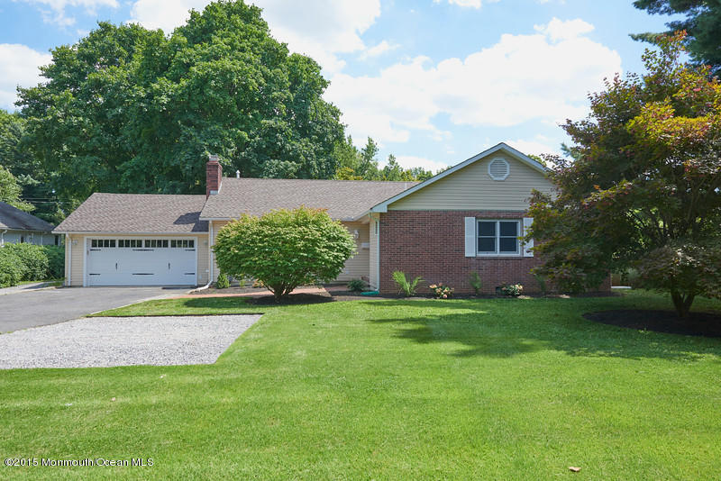 a view of a house with a big yard potted plants and large tree