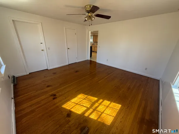a view of empty room with wooden floor