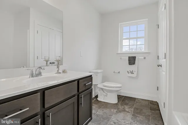 a bathroom with a sink a toilet and a window