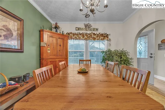 a dining room with furniture a chandelier and wooden floor
