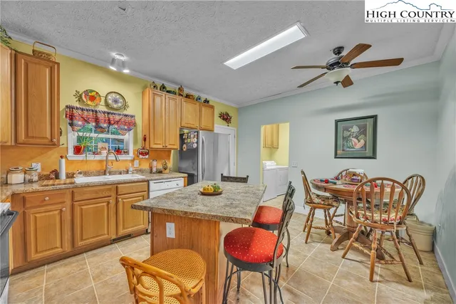 a dining room with stainless steel appliances granite countertop furniture a window and a refrigerator
