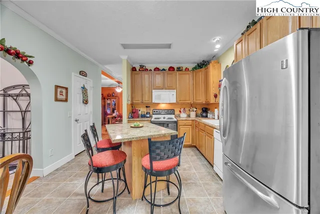 a kitchen with a refrigerator and table chairs