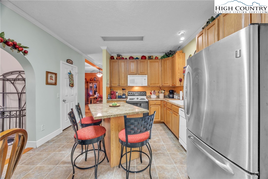 3786 Peak Road Creston, NC 28615 - Photo 17 of 44 a kitchen with a refrigerator and table chairs