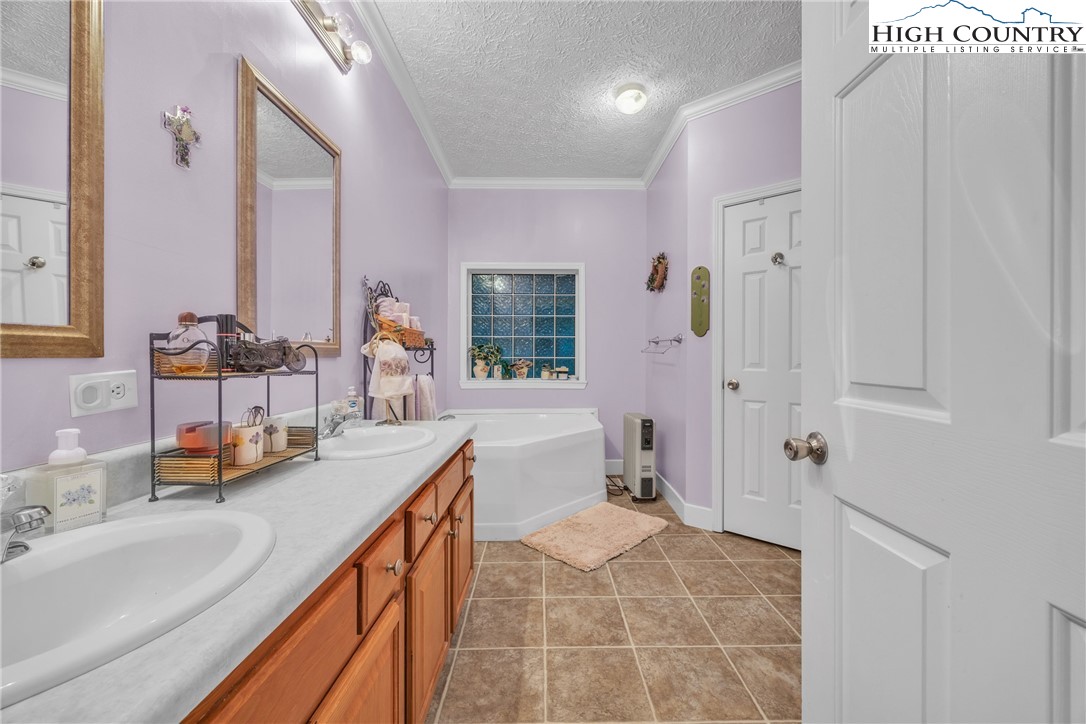 3786 Peak Road Creston, NC 28615 - Photo 18 of 31 a bathroom with a double vanity sink mirror and shower