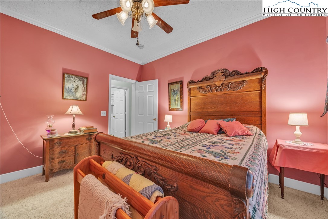 3786 Peak Road Creston, NC 28615 - Photo 24 of 44 a bedroom with a bed and a chandelier