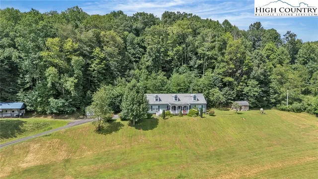a view of a lush green field with a house in the background