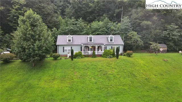 a view of a big house with a big yard and large tree