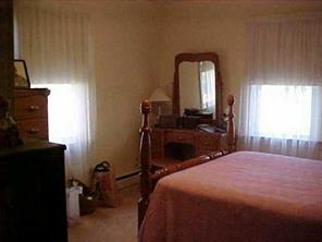 870 Parks Road Woodleaf, NC 27054 - Photo 3 of 8 a bedroom with a bed and a mirror on dresser