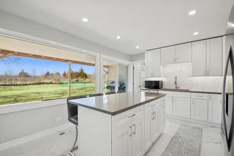 a large kitchen with kitchen island and a large window
