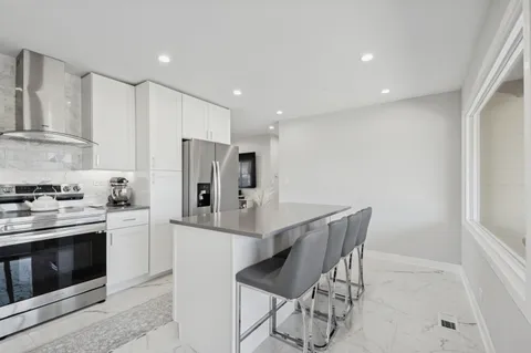 a kitchen with stainless steel appliances a stove a refrigerator sink and cabinets