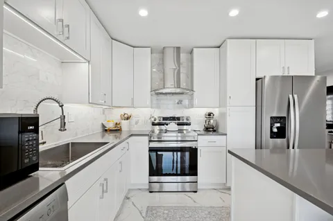a kitchen with stainless steel appliances granite countertop a sink stove and refrigerator