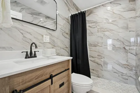 a bathroom with a sink a toilet and shower