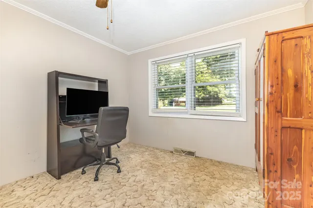 a view of a workspace with furniture and a window
