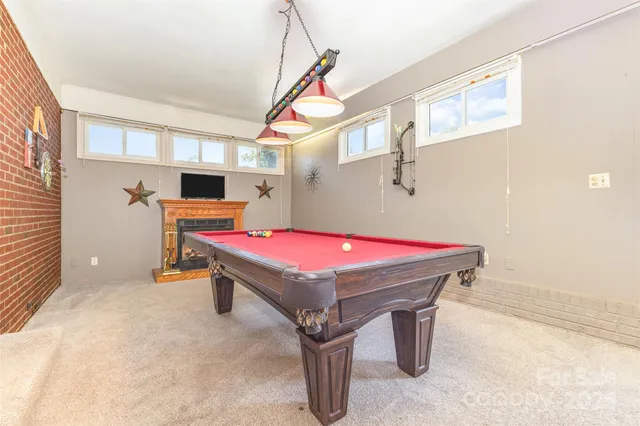 a room with pool table and windows