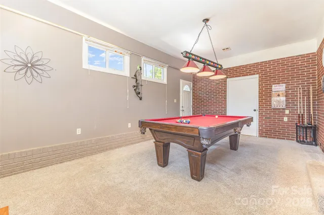 a room with pool table and windows