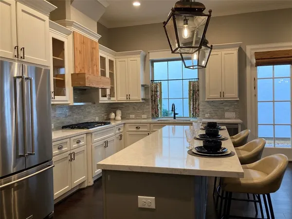 a kitchen with stainless steel appliances granite countertop a sink a stove and a refrigerator