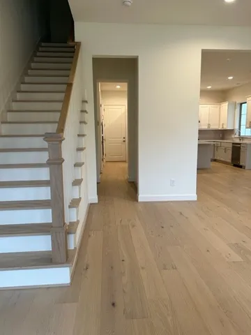 a view of a hallway with wooden floor and staircase