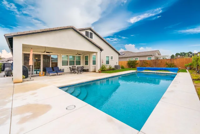 a swimming pool with outdoor seating and yard