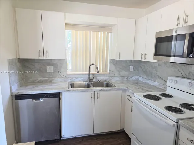 a kitchen with a sink stove and cabinets