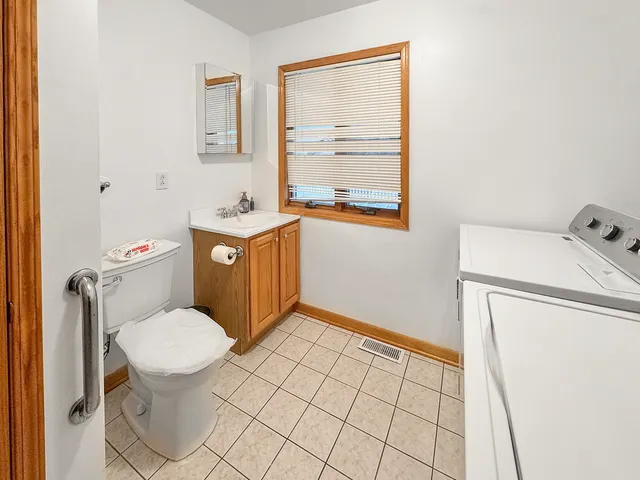 an empty room with wooden floor closet and windows