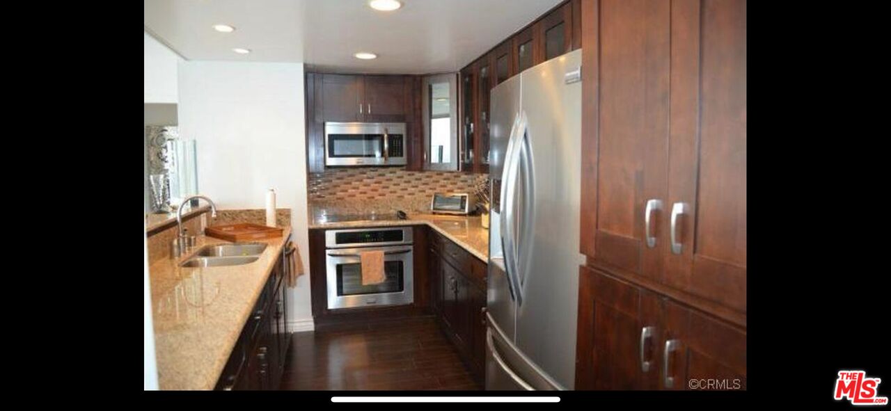 2170 Century Park East, Unit 1611 Los Angeles, CA 90067 - Photo 11 of 41 a kitchen with stainless steel appliances granite countertop a refrigerator and a stove