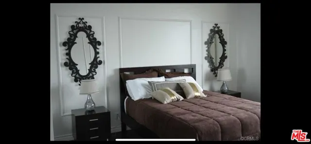a bedroom with a bed and a painting on the wall