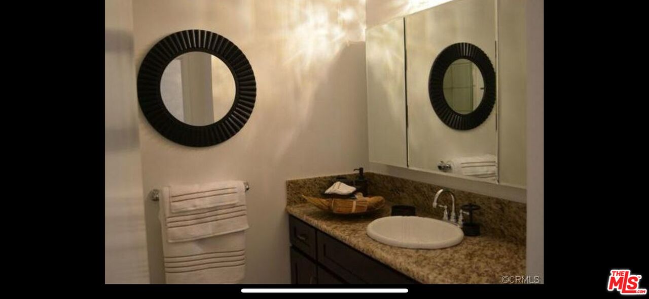2170 Century Park East, Unit 1611 Los Angeles, CA 90067 - Photo 16 of 41 a bathroom with a granite countertop sink and a mirror