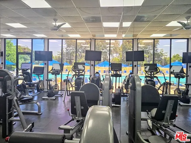 a room with gym equipment and a view of chandelier
