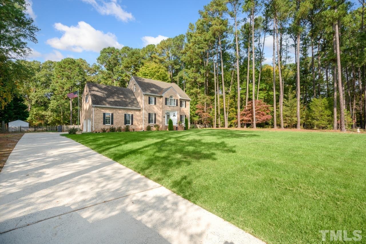 11915 Shooting Club Road Raleigh, NC 27613 - Photo 2 of 8 a view of a house with a big yard and large trees