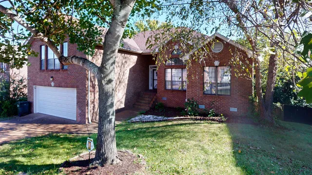 a view of house with a yard and potted plants