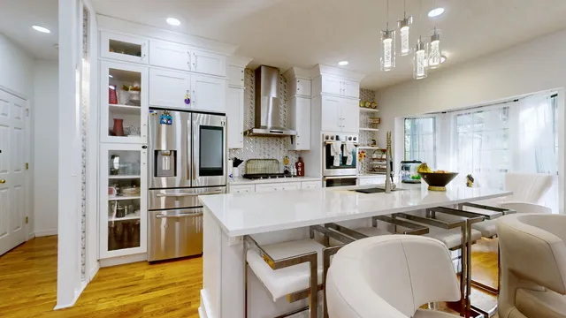 a kitchen with kitchen island a large counter top appliances and cabinets