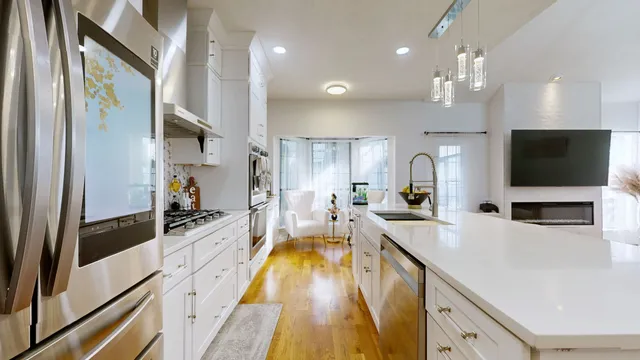 a large kitchen with kitchen island a large counter top space a sink stainless steel appliances and cabinets