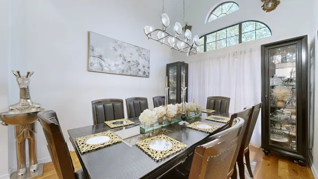 a view of a dining room with furniture a chandelier and wooden floor