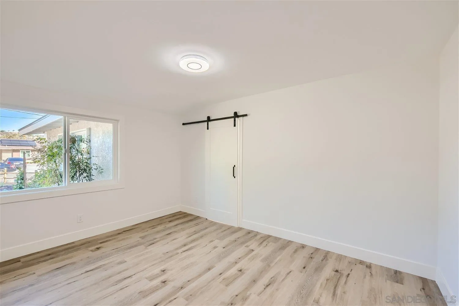 14222 Halper Road Poway, CA 92064 - Photo 17 of 30 an empty room with wooden floor and windows