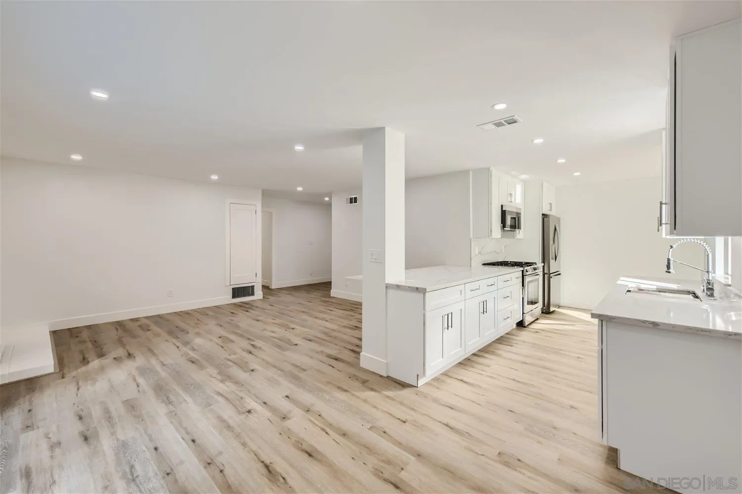 14222 Halper Road Poway, CA 92064 - Photo 5 of 30 a large white kitchen with kitchen island a sink stainless steel appliances and cabinets
